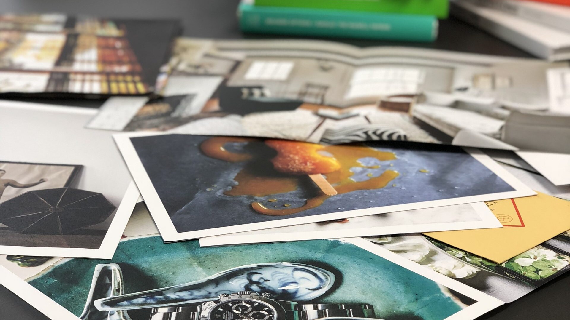 Printed photo assets sit on a desk.