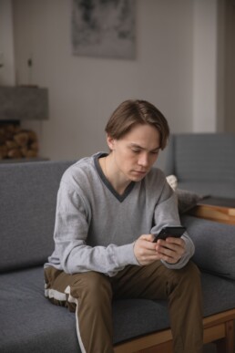 Person using mobile design as they sit on their couch.