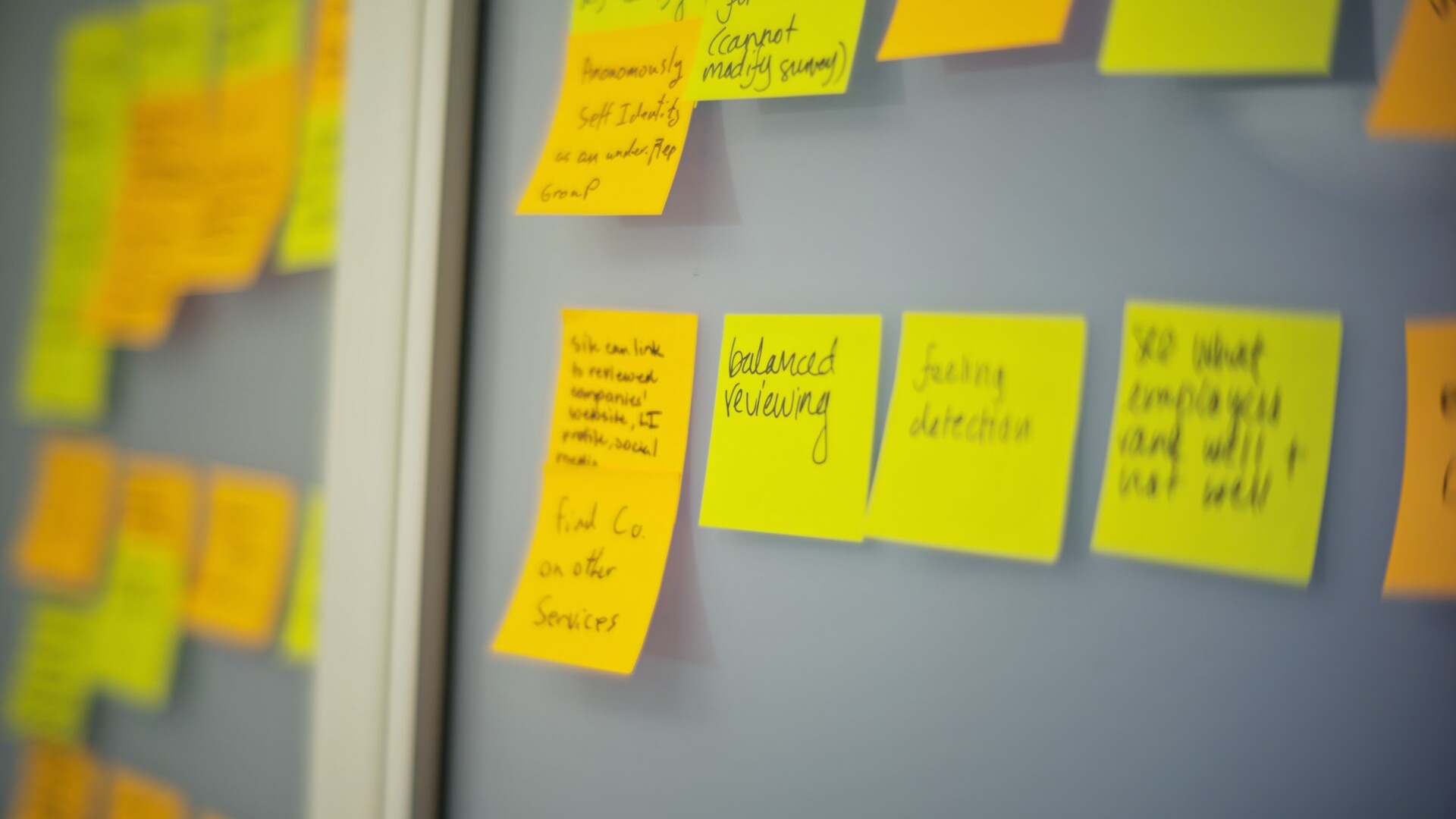 Sticky notes outlining project process on a whiteboard.