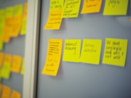 Sticky notes outlining project process on a whiteboard.