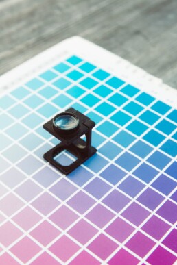 A color chart of blue and purple hues sit on a desk.