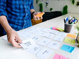 Designer performing UX research and organizes thoughts with post-its.