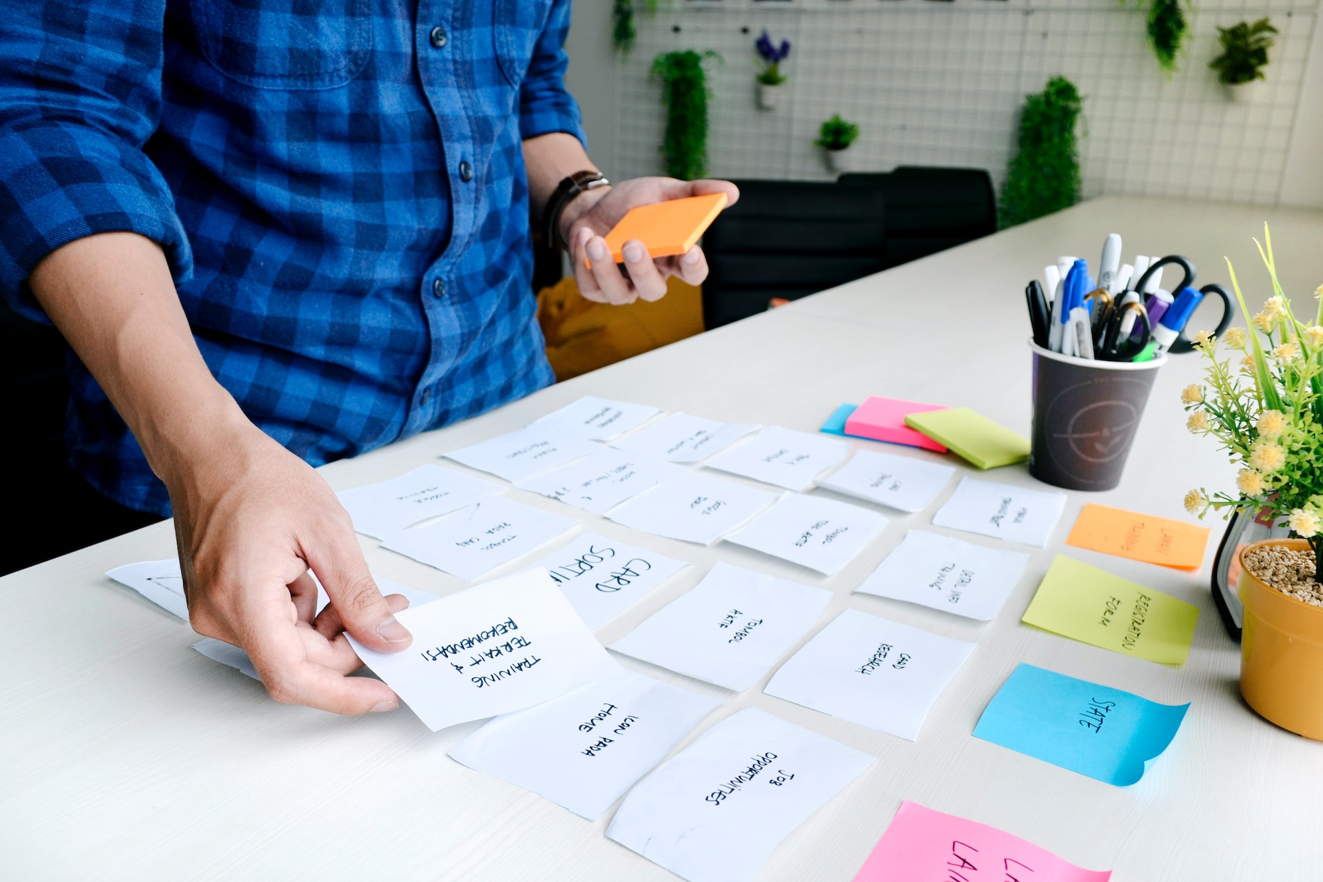Designer performing UX research and organizes thoughts with post-its.