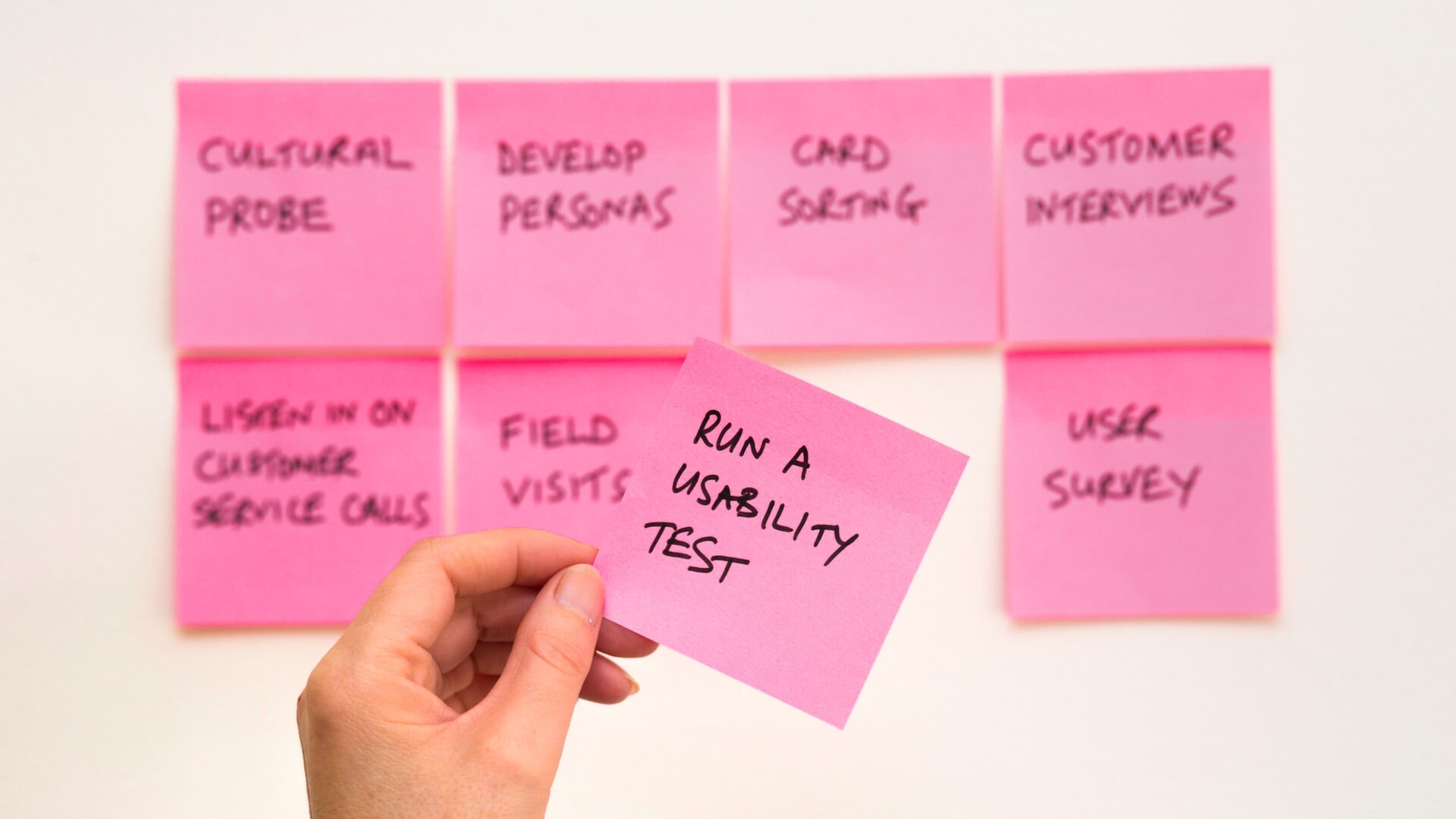 Person holding post-it note with words run web usability testing