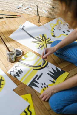 Person painting abstract designs on paper.
