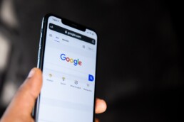 A close-up of a phone on Google's search bar.