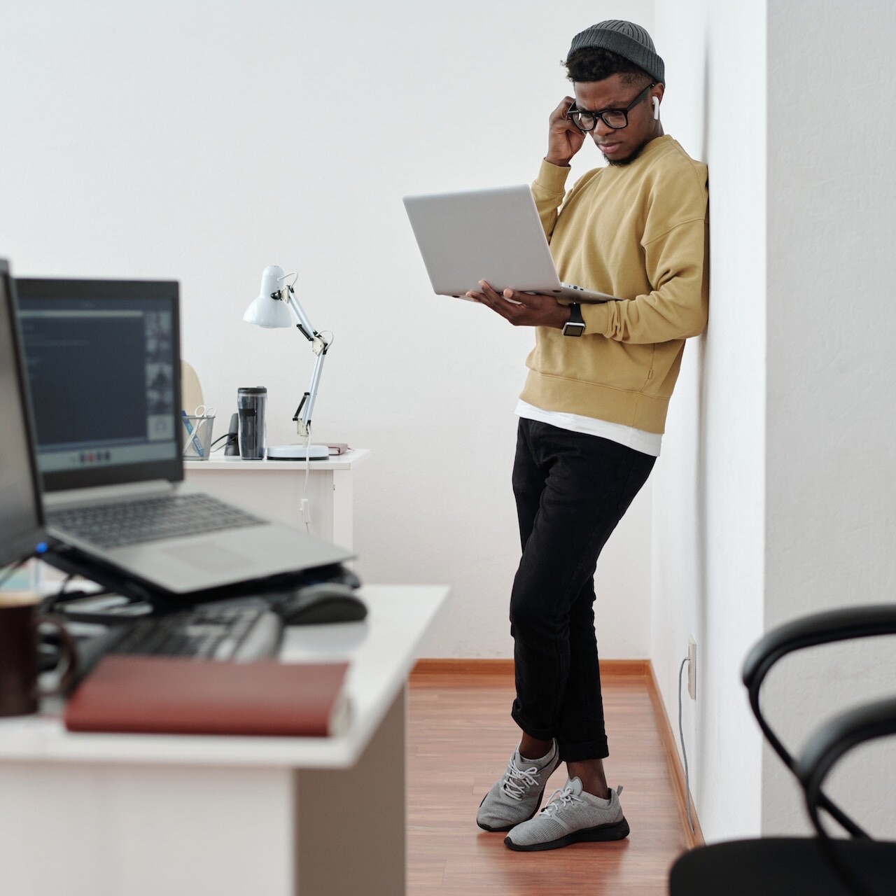 a person standing and holding their laptop