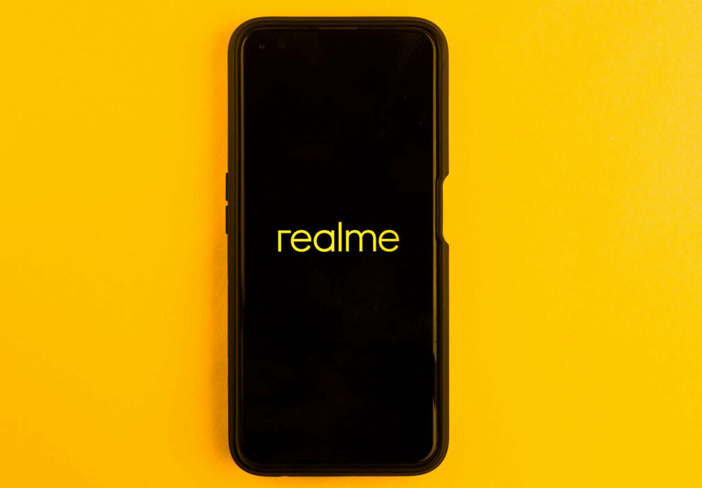 Mobile device displaying “realme” message.