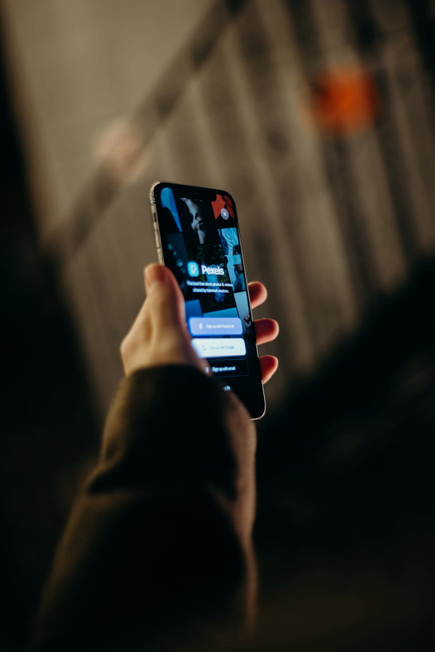 Person holding a phone with a dark mode user interface.